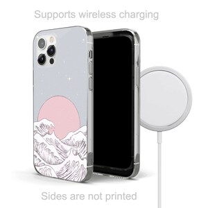 Puede incluir: Una funda transparente para tel&eacute;fono con un dise&ntilde;o de olas y luna rosa y blanco. La funda es compatible con la carga inal&aacute;mbrica. El texto "Supports wireless charging" se muestra encima de la funda. El texto "Sides are not printed" se muestra debajo de la funda.
