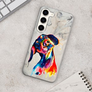 May include: A white phone case with a marble pattern and a colorful abstract painting of a dachshund dog. The dog is painted in shades of blue, green, yellow, orange, and red.