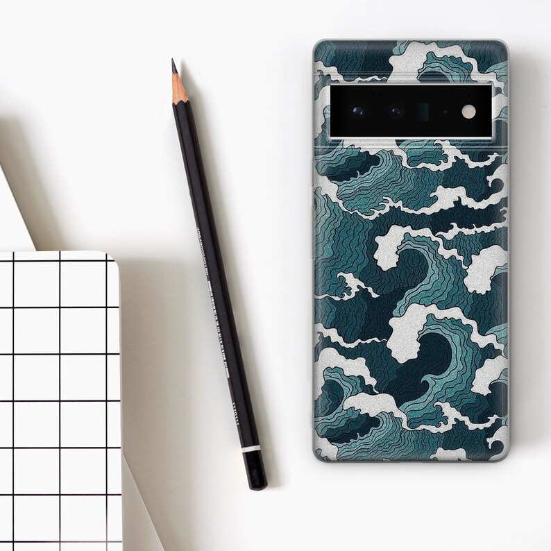 Puede incluir: Una funda transparente para tel&eacute;fono con un patr&oacute;n de olas azules y blancas. La funda tiene un recorte para el objetivo de la c&aacute;mara.