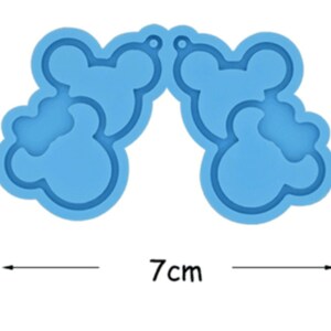 May include: A blue silicone mold for making resin earrings. The mold is shaped like two pairs of cartoon ears, each with a hole at the top for hanging. The mold measures 7 inches wide and 4 inches tall.