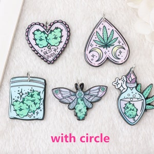 May include: Five different charm pendants with a green marijuana leaf design. The charms are in the shapes of a heart, a teardrop, a bag, a moth, and a bottle. The charms are all made of metal and have a shiny finish.
