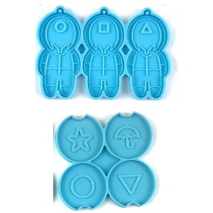 May include: A blue silicone mold with three astronaut shapes and four round shapes. The astronaut shapes have a circle, square, and triangle on their heads. The round shapes have a star, umbrella, circle, and triangle.