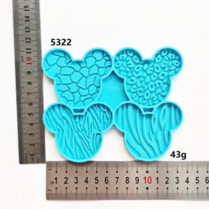 May include: Blue silicone mold with four different animal print designs. The mold is shaped like four Mickey Mouse ears. The mold is 10 cm wide and weighs 43 grams. The mold is labeled with the number 5322.