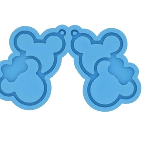 May include: A blue silicone mold for making resin earrings. The mold is shaped like two pairs of Mickey Mouse ears.