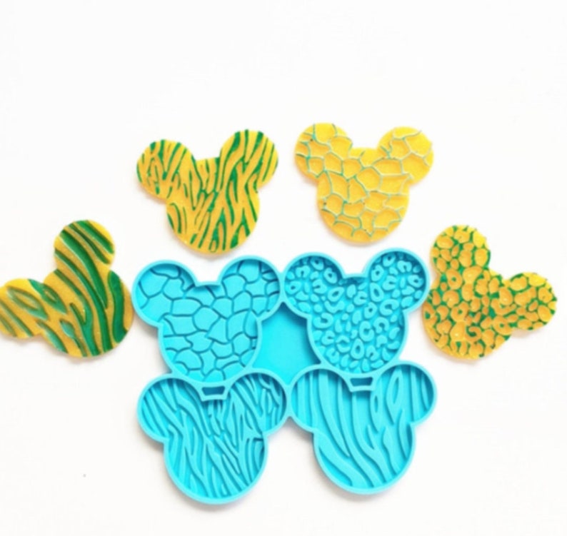 May include: A set of six silicone molds shaped like Mickey Mouse ears. The molds are blue and feature different animal print designs, including zebra, leopard, and giraffe.