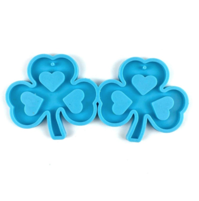 May include: Two blue silicone molds shaped like shamrocks with three heart-shaped cavities in each shamrock.