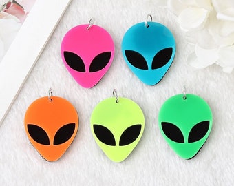 May include: Five neon alien head shaped charms with black eyes. The charms are pink, blue, orange, green, and lime green.