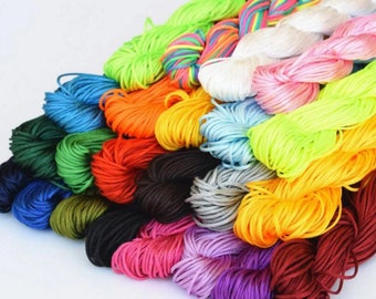 May include: A collection of colorful waxed cotton cords, perfect for crafting bracelets, necklaces, and other jewelry. The cords are arranged in a fan shape, showcasing a variety of vibrant hues.