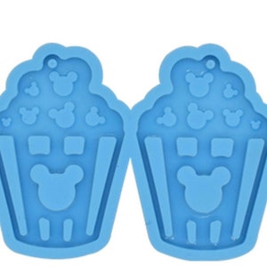 May include: Two blue silicone molds for making resin earrings. Each mold features a popcorn bucket with Mickey Mouse ears and popcorn pieces.