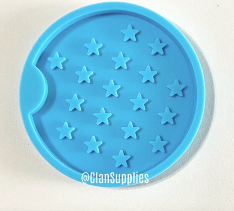 May include: A light blue silicone coaster mold with a cutout for a cup and a design of 18 stars. The mold is for making resin coasters. The text "@ClanSupplies" is at the bottom of the mold.