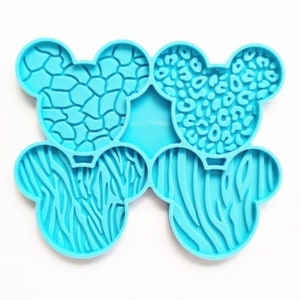 May include: A blue silicone mold with six different animal print designs. The mold is shaped like a pair of ears and has a raised design.