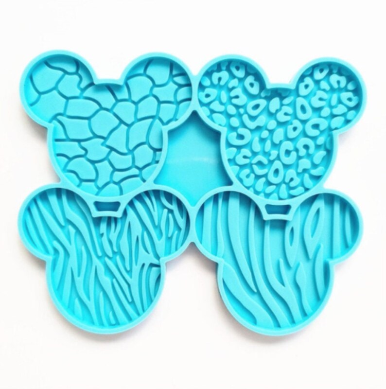 May include: A blue silicone mold with six different animal print designs. The mold is shaped like a pair of ears and has a raised design.