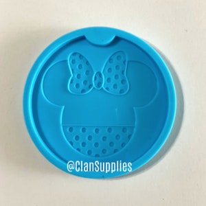 May include: Blue silicone mold with a Minnie Mouse design. The mold features a polka dot bow and dress.