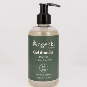 Peut inclure: Une bouteille en plastique transparente de gel douche avec un distributeur à pompe noir. La bouteille porte une étiquette verte avec le texte "Angeliki skincare Gel douche BALI TEA The Blanc & Bamboo 92% d'ingrédients d'origine naturelle TOUS TYPES DE PEAUX 250ml 8.45 fl oz e".