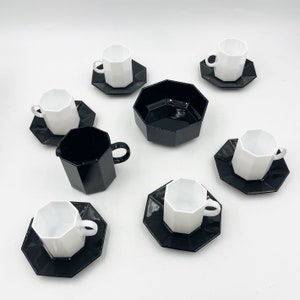 Peut inclure: Un service à thé octogonal noir et blanc avec une crémier, un sucrier et six tasses et soucoupes.