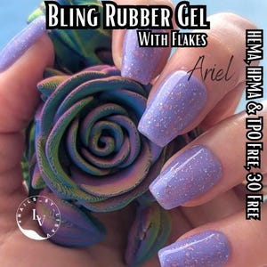 May include: Purple nail polish with iridescent glitter flakes. The polish is labeled "BLING RUBBER GEL WITH FLAKES Ariel" and "HEMA, HPMA & TPO FREE, 30 FREE".