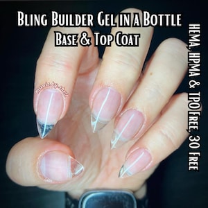May include: Close-up of a hand with clear nail polish applied to each fingernail. The nails are shaped into a long, pointed shape. The text "BLING BUILDER GEL IN A BOTTLE BASE & TOP COAT" is at the top of the image. The text "HEMA, HPMA & TPO FREE. 30 FREE" is on the right side of the image.
