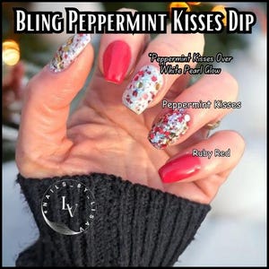 May include: Close-up of a hand with red and white glitter nail polish. The nails are decorated with red and white glitter, and the text "Peppermint Kisses Over White Pearl Glow" and "Peppermint Kisses" is visible. The nail polish is called "Ruby Red".