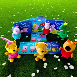 May include: A selection of Peppa Pig books and soft toys arranged on a green surface. The books feature titles such as "Peppa Goes Swimming" and "Peppa Goes Shopping." The toys include Peppa Pig and other characters from the series.