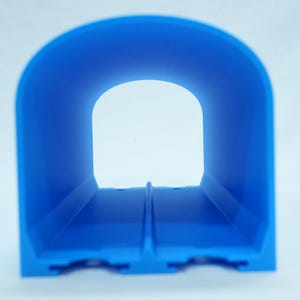 Pu&ograve; includere: Un oggetto blu brillante a forma di tunnel con una base rettangolare e una parte superiore ad arco. Il tunnel ha un interno cavo e un'apertura trasparente all'estremit&agrave;. L'oggetto &egrave; realizzato in un materiale solido ed &egrave; posto su uno sfondo bianco.