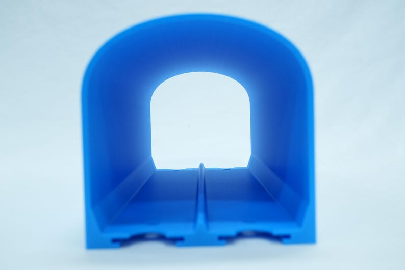 Pu&ograve; includere: Un oggetto blu brillante a forma di tunnel con una base rettangolare e una parte superiore ad arco. Il tunnel ha un interno cavo e un'apertura trasparente all'estremit&agrave;. L'oggetto &egrave; realizzato in un materiale solido ed &egrave; posto su uno sfondo bianco.