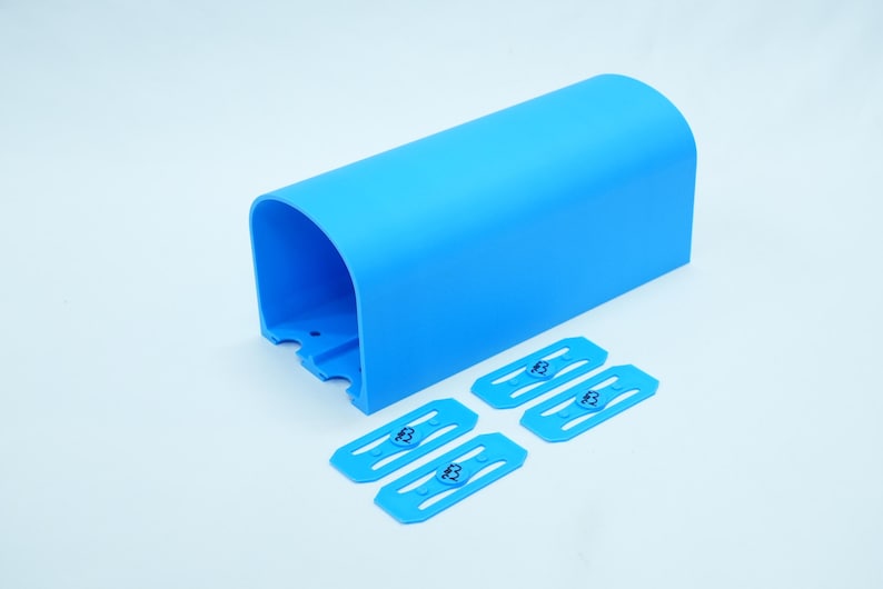 Pu&ograve; includere: Un componente in plastica blu brillante, arcuato, con quattro clip blu abbinate. Le clip presentano un logo "B" stilizzato. Il componente ha una parte superiore curva e un'estremit&agrave; aperta.