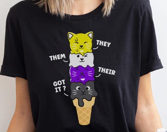 Op de afbeelding: Zwart T-shirt met een afbeelding van een stapel ijshoorns met kattengezichten. De ijshoorns zijn gelabeld met "They", "Them", "Their", en "Got it?"