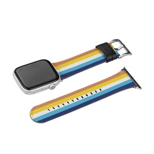 Op de afbeelding: Een kleurrijk gestreept Apple Watch bandje met een wit, geel, blauw en oranje ontwerp. Het bandje is gemaakt van leer en heeft een zilveren gesp.