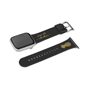 Op de afbeelding: Zwart leren Apple Watch-band met gouden tekst die "plays well with others" zegt en een zwart leren band met een gouden ananasontwerp.