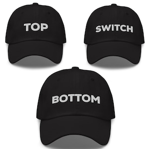 May include: Three black baseball caps with white embroidered text. The caps read "TOP", "SWITCH", and "BOTTOM".