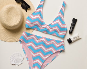 Pode incluir: Um top e uma parte inferior de biquíni com padrão chevron rosa e azul. O top do biquíni tem um decote redondo e alças ajustáveis. A parte inferior do biquíni tem uma perna de corte alto e costas completas.