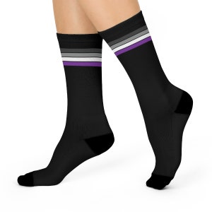 May include: A pair of black socks with a purple, white and grey stripe pattern. The stripes are reminiscent of the asexual pride flag.