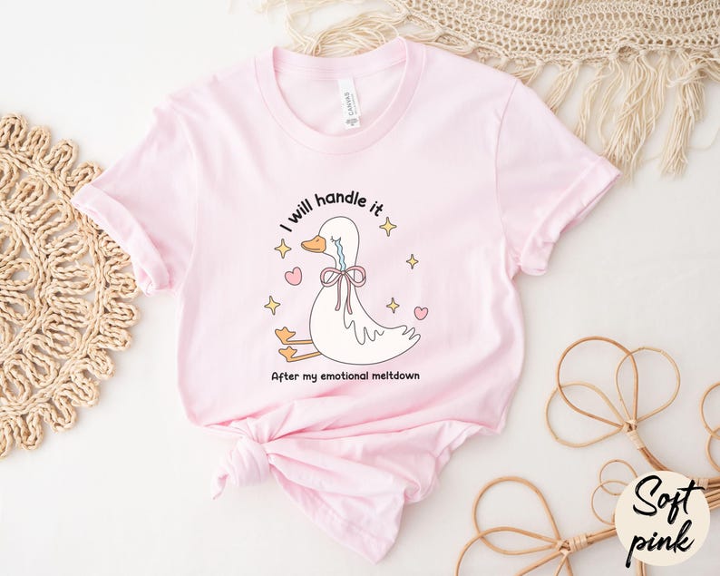 Puede incluir: Una camiseta rosa con una ilustraci&oacute;n de un pato llorando. El texto en la camiseta dice "Lo manejar&eacute; despu&eacute;s de mi crisis emocional."