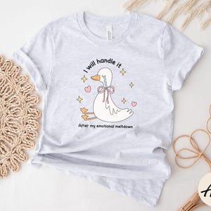 Puede incluir: Una camiseta blanca con un ganso de dibujos animados llorando y el texto "Lo manejar&eacute; despu&eacute;s de mi crisis emocional".