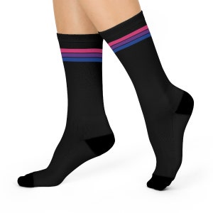 May include: Black socks with a horizontal stripe pattern in pink, blue and purple. The socks are shown on a model's feet.