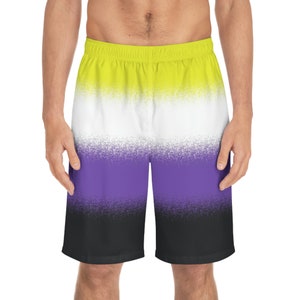 May include: Non-binary pride flag swim trunks. The shorts feature a gradient design with yellow, white, purple, and black colors. The waistband is yellow. The shorts are knee-length and made of a lightweight material.