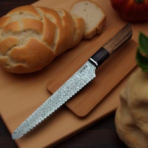 May include: A bread knife with a wooden handle and a wavy, patterned blade. The knife is on a wooden cutting board.