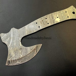 以下が含まれることがあります： 独特な模様のダマスカス鋼製のハンドメイドの斧ヘッド。斧ヘッドは湾曲した刃とストレートなハンドルを持っています。ハンドルは、吊り下げ用の穴が端にあります。