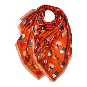 May include: An orange scarf with a repeating pattern of whimsical animal illustrations in various colors. The scarf has a fringed edge and is made of a silky material. The design includes cats, dogs, and other creatures.
