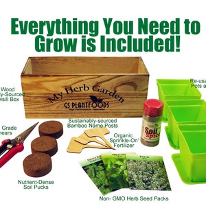 May include: A wooden windowsill planter box with the text "My Herb Garden" and "GS Plantfoods" on the front. The box is filled with soil pucks, bamboo plant markers, and three packets of herb seeds. There is also a small container of organic fertilizer and a pair of gardening shears. The box is surrounded by four green plastic planter pots with saucers.