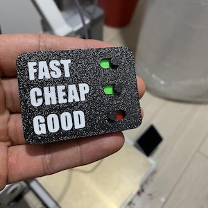 Könnte beinhalten: Eine weiße Keramik-Tasse mit schwarzem Henkel und dem Text "But First, Coffee" in schwarzer, handschriftlicher Schrift. Die Tasse steht auf einer weißen Oberfläche.