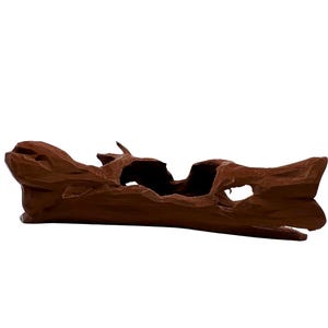 Può includere: Un pezzo decorativo in legno intagliato marrone con una forma naturale e organica. Il legno ha un colore ricco e scuro e presenta diverse aperture e aree scavate, creando un aspetto unico e strutturato. Il pezzo è progettato per essere un accento decorativo.