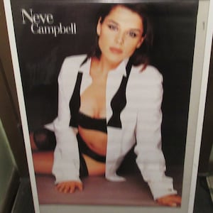 May include: A black and white poster featuring a photo of Neve Campbell. The poster has the text "Neve Campbell" in white letters at the top.