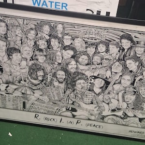 Puede incluir: Obra de arte enmarcada en blanco y negro que representa a numerosos músicos. La obra de arte incluye el texto "R. (ROCK) I. (IN) P. (PEACE)" y el nombre del artista "HOWARD TEMAN". La obra de arte está presentada en un marco negro.