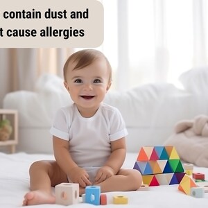 May include: A smiling baby sits on a white surface surrounded by colorful wooden blocks. The blocks are various shapes and colors, including blue, yellow, red, and green. Text above the baby reads, "Does not contain dust and does not cause allergies."