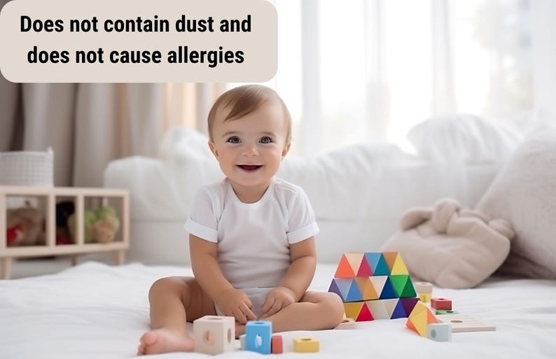 May include: A smiling baby sits on a white surface surrounded by colorful wooden blocks. The blocks are various shapes and colors, including blue, yellow, red, and green. Text above the baby reads, "Does not contain dust and does not cause allergies."