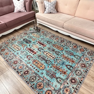May include: A blue and brown patterned rug with a geometric design. The rug has a light blue background with brown, red, and yellow accents.