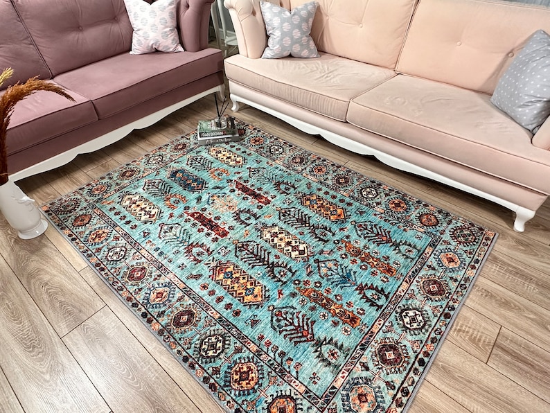 May include: A blue and brown patterned rug with a geometric design. The rug has a light blue background with brown, red, and yellow accents.