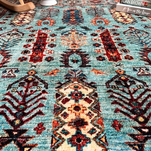 May include: A teal blue rug with a traditional Persian design featuring intricate patterns in shades of red, brown, and cream.
