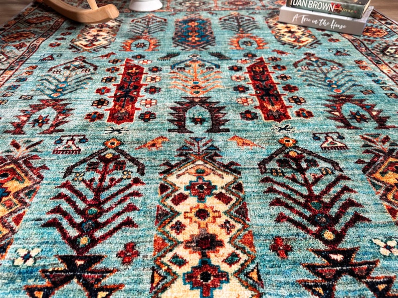 May include: A teal blue rug with a traditional Persian design featuring intricate patterns in shades of red, brown, and cream.
